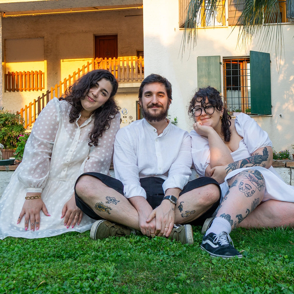 Riccardo, Sara e Rachele seduti sull'erba con i mazzi di carte in mano