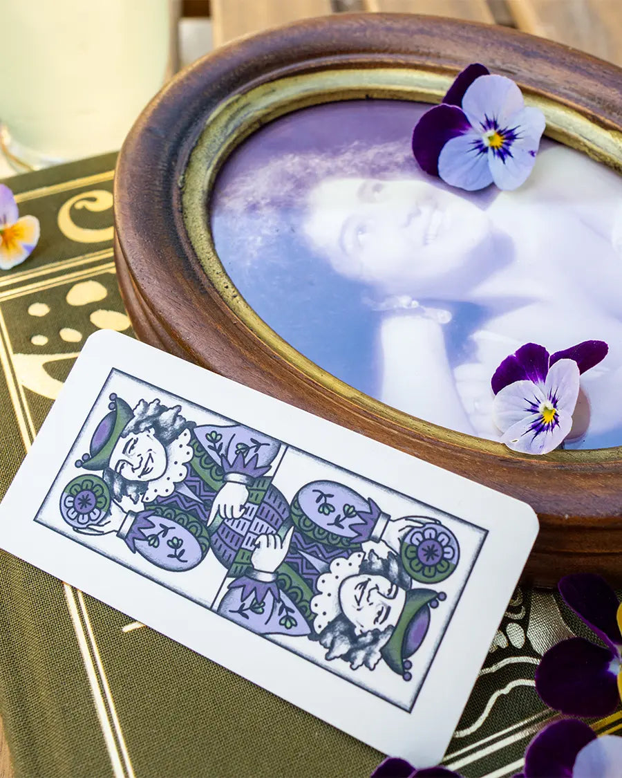 carte accanto a una bevanda lilla decorata con le viole