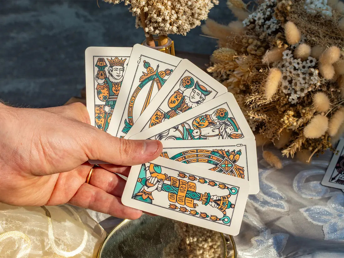 un ventaglio di carte arancio e turchese tenuto in mano